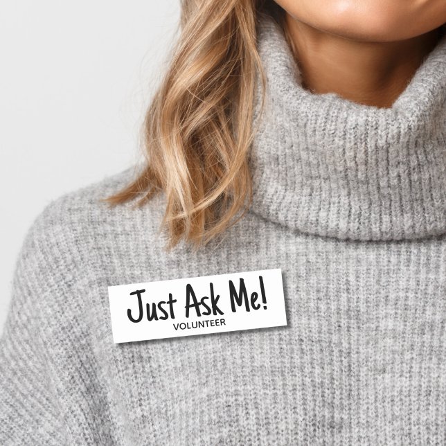 Etiqueta De Nome Voluntário Pergunte-me Simples (Woman wearing gray sweater with black and white "just ask me" volunteer name tag badge.)