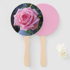 Foto de uma rosa rosa em um leque manual