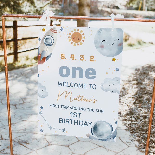 Foto Primeiro sinal de boas-vindas ao primeiro aniversa (Outer space or first trip around the sun 1st birthday welcome sign with moon, sun and astronaut.)