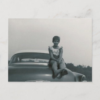 garota bonita sentada atrás do velho cartão poste