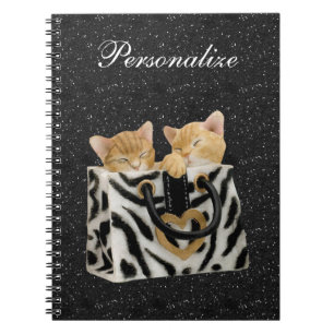 Gatinhos no caderno do brilho do preto da bolsa da