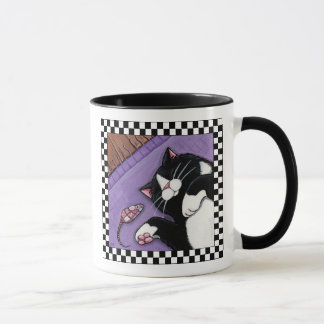 Gato do smoking que dorme perto da caneca da arte
