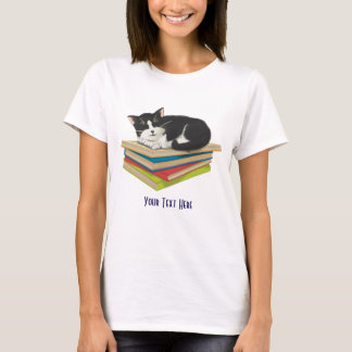 Gato dormindo em camisa de livros