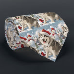 Gravata Alaskan Malamute Dog Winter Wonderland Christmas<br><div class="desc">seu design festivo captura o espírito alegre da época de férias, apresentando um adorável filhote vestindo um chapéu de Papai Noel. O gato está aninhado numa terra maravilhosa de inverno, completo com um boneco de neve, uma árvore de Natal decorada, e presentes lindamente envoltos. Os flocos de neve caem suavemente,...</div>