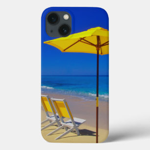 Guarda-chuva de praia amarelo e cadeiras em praia 