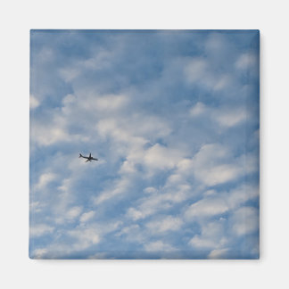 Íman Airplane Crossing a Cloud-Filled Blue Sky