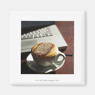 Íman Cappuccino na frente do laptop