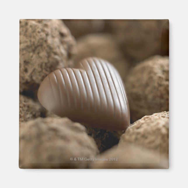 Íman chocolate aninhado entre outros chocolates (Frente)