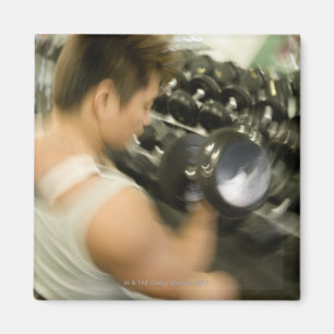 Íman Equipe o dumbbell de levantamento no gym, opinião