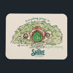 Íman Everything Grows in THE SHIRE™<br><div class="desc">Bring a little piece of Middle-Earth™ to your everyday with this charming Lord of the Rings™ design inspired by the cozy hills of Hobbiton. Featuring a storybook-style hobbit hole with its iconic round green door tucked into a lush hillside, the artwork is paired with the beloved phrase, “Everything grows in...</div>