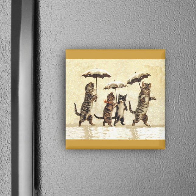 Íman Família de Gatos com Guarda-chuvas Andando na Neve (Four brown cats walking upright in snow with umbrellas on yellow square magnet.)