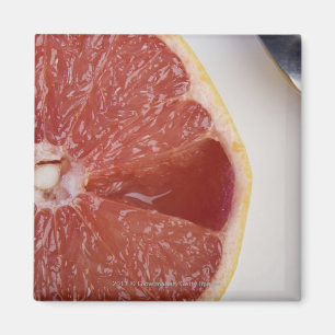 Íman Fim-acima de uma fatia de laranja e de uma colher