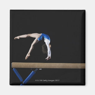Íman Gymnast (9-10) que lança no feixe de equilíbrio,