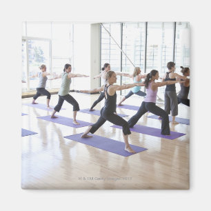 Íman Instrutor da ioga ensinando uma classe de mulheres