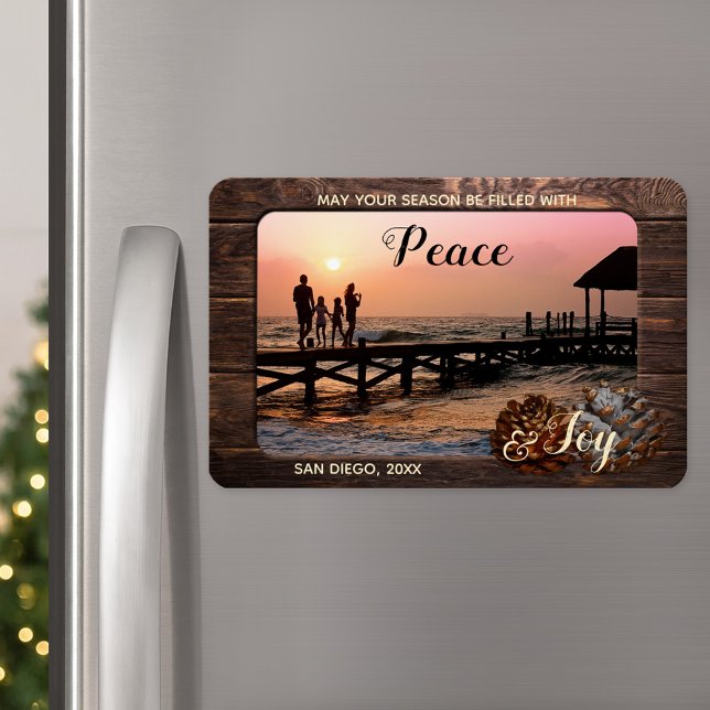 Íman Magnet de Fotografia de Férias Personalizadas da M (A Christmas magnet featuring your custom photo framed by rustic dark wood and festive pine cone)