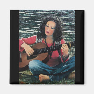 Íman Mulher que joga a música com guitarra acústica