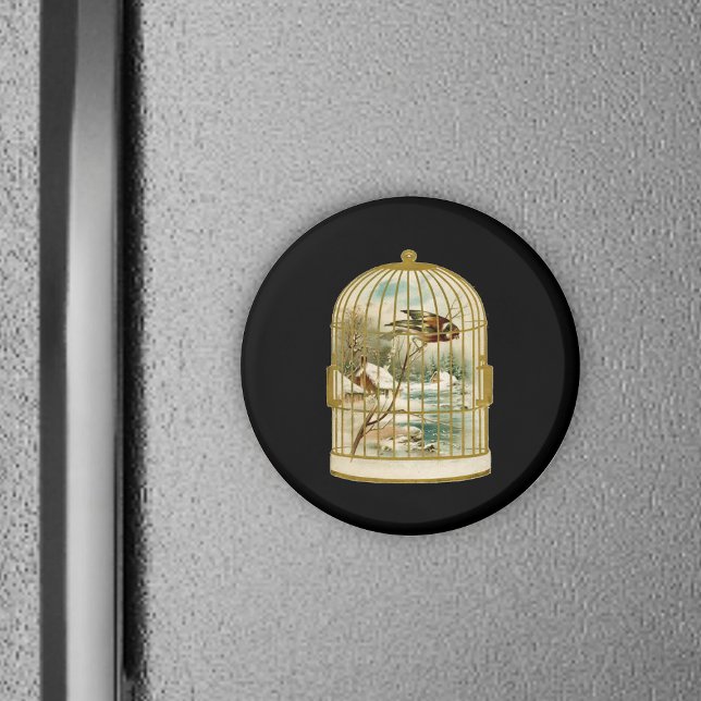 Íman Pássaro Na Cena De Inverno Da Gaiola (Golden birdcage with winter cabin scene inside bird on branch on black round magnet.)