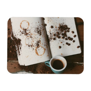 Íman Um café quente com livro e feijão manchados