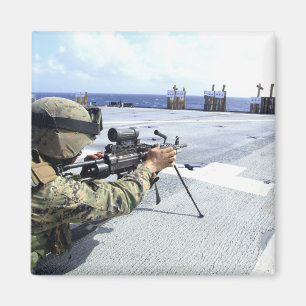 Íman Um fuzileiro naval dos E.U. que ajusta sua arma