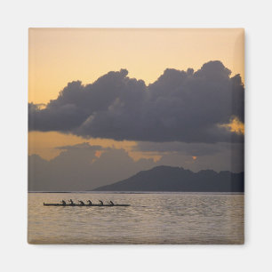 Íman Uma equipe de canoa outrigger pratica na costa