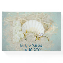 Anéis de Casamento e Seashell na Areia