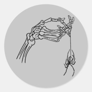 Mão de esqueleto com adesivo de aranha