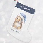 Meia De Natal Pequena Coelhinho no Papai noel Azul Personalizado<br><div class="desc">Papais noeis de Natal personalizados Bunny Stocking, perfeitos para seus pequenos nesta temporada de festas. Essa estocagem adorável apresenta um belo coelhinho vestindo um chapéu de Papai noel azul coberto de neve. A reserva pode ser personalizada com o nome do seu filho. Segure-o na sua manta ou no quarto do...</div>