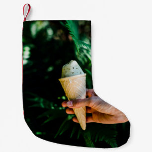 Meia De Natal Pequena Pessoa que detém o sorvete