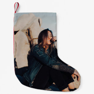 Meia De Natal Pequena Sentada e sorridente vestindo calças pretas