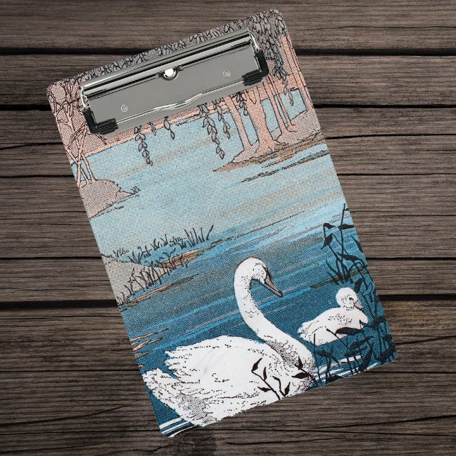 Mini Prancheta Mãe Cisne Branco Nadando no Lago Com Bebê (Elegant white swan swimming in blue lake with her baby swan on clipboard.)