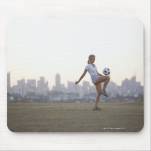 Mousepad Bola de futebol kneeing da mulher no parque urbano