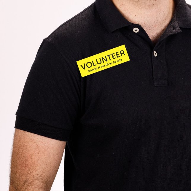 Nome de etiqueta do Crachá de Voluntário Amarelo (Man in black shirt wearing this customizable volunteer name tag badge in yellow.)