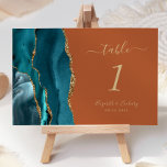 Numeração De Mesa Casamento Laranja De Teal Dourado Agate Queimado<br><div class="desc">A borda esquerda desta elegante e moderna placa de número da mesa de casamento apresenta uma cor azul-lacrimogênea,  borda agitada com falso brilho dourado. O texto personalizável combina letras douradas,  letras itálicas e placas em um fundo laranja queimado.</div>
