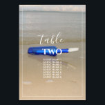 Numeração De Mesa Garrafa na praia Areia Nomes de Convidados<br><div class="desc">Esta design apresenta uma garrafa na praia. A bela cor azul da garrafa contrasta com a areia ouro, criando uma combinação perfeita. A borda branca fina enquadra perfeitamente a garrafa azul lavada na areia e combina com a tipografia branca moderna. Design de praia romântica com uma mistura de simplicidade e...</div>