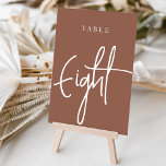 Numeração De Mesa Mesa com script de mão enferrujada OITO<br><div class="desc">Cartões simples e chic em tons de terra, marrom e branco, fazem uma declaração elegante no seu casamento ou evento. Design apresenta "mesa [number]" em uma combinação de olhares de serif clássica e de caracteres de script manuscritos. Design repete-se de ambos os lados. Cartões numerados individualmente vendidos separadamente; solicite cada...</div>