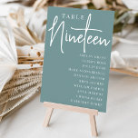 Numeração De Mesa Mesa com script manual NINETEEN   Nomes de convida<br><div class="desc">Cartões simples e chic de mesa, em cor poeirenta e branco, fazem uma declaração elegante no seu casamento ou evento. Design apresenta "mesa [number]" em uma combinação de olhares de serif clássica e de caracteres de script manuscritos, com nomes individuais de convidados por baixo. Design repete-se de ambos os lados....</div>