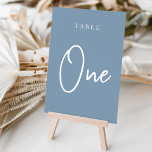 Numeração De Mesa Mesa ONE com script de mão azul empoeirada<br><div class="desc">Cartões simples e chic em azul e branco empoeirados fazem uma declaração elegante no seu casamento ou evento. Design apresenta "mesa [number]" em uma combinação de olhares de serif clássica e de caracteres de script manuscritos. Design repete-se de ambos os lados. Cartões numerados individualmente vendidos separadamente; solicite cada número de...</div>