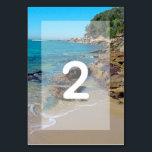 Numeração De Mesa Rocky Beach Wedding<br><div class="desc">Esta design de praia apresenta uma costa rochosa. O cenário pitoresco combina verde, oceano azul, costa rochosa e areia ouro. A formulação é elegantemente enquadrada por um simples fundo branco opaco de fronteira. Este é o perfeito design de casamento de destino de praia ideal para um casamento de verão ou...</div>
