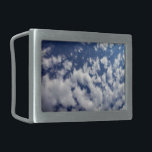 Nuvens Puffy No Céu Azul<br><div class="desc">Um banco de nuvens brancas indefinidas se quebra em pequenas peças sábia através do quadro da fotografia vertical. O cobrir da nuvem é mais denso à esquerda e mais esparso à direita, revelando um céu azul profundo que é escuro perto do topo da foto e mais claro perto do fundo....</div>