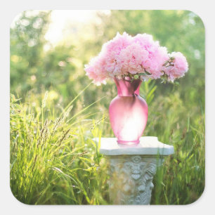 O vaso de vidro bonito do rosa floresce etiquetas