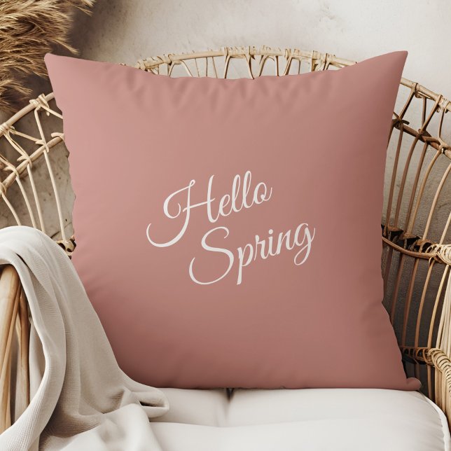 Olá Almofada de Lançamento Rosa Poeira Primavera (Hello Spring Dusty Rose Throw Pillow in a boho rattan armchair.)