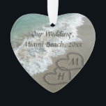 Ornamento Corações de bloqueio da lembrança do casamento de<br><div class="desc">Corações elegantes da areia escritos na praia agradável para simbolizar um casamento do destino ou umas férias tropicais do viagem da lua de mel. Imagem cénico bonita da água clara do oceano de turquesa do aqua, com as ondas brancas que deixam de funcionar na praia tan da areia. Dois corações...</div>