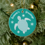 Ornamento De Cerâmica A Tartaruga de Natal Bonita e Saudações da Tempora<br><div class="desc">Adorável Enfeites de natal azul com uma tartaruga,  flocos de neve e as palavras Saudações de Season. Na parte de trás do ornamento,  ele lê Do,  depois adicione seu próprio nome para personalizar. Toda a redação deste ornamento festivo é habitual.</div>