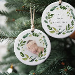 Ornamento De Cerâmica Alabastro Wreath Baby Photo Christmas<br><div class="desc">O ornamento de fotos redondas apresenta sua pequena foto emoldurada por uma coroa de folhagem botânica verde e flores brancas. Personalize as costas com sua legenda personalizada (mostrada com "[name's] first Christmas" e o ano.</div>