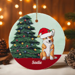 Ornamento De Cerâmica Árvore de Natal Monograma de Corgi Santa Hat<br><div class="desc">Este lindo cão Pembroke Welsh Corgi tem um chapéu bonito de Papai Noel e uma adorável inclinação da cabeça. O filhote de tricolor está sentado em frente a uma bonito árvore de Natal decorada com ornamentos coloridos. Personalize o nome do seu animal de estimação em encantador cursivo sob o maravilhoso...</div>