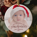 Ornamento De Cerâmica Avós Primeiro Foto de Natal - Script Vermelho<br><div class="desc">Ajudem-nos a celebrar o seu primeiro neto com este belo ornamento moderno do keepsasawn. O texto vermelho burgundy lê "Nosso primeiro Natal como avós", com a palavra "avós" em uma escrita elegante com flores antes e depois. Substitua facilmente a imagem de amostra pela sua foto favorita do novo bebê, e...</div>