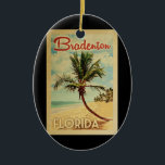 Ornamento De Cerâmica Bradenton Palm Viagens vintage<br><div class="desc">Um impressão de arte moderno do século médio,  Bradenton Florida,  no estilo viagens vintage. Ele apresenta uma palmeira curva na praia arenosa com oceano sob um céu azul nublado.</div>