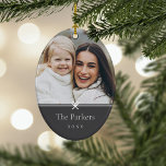 Ornamento De Cerâmica Cinza | Foto mínima simples do Arco<br><div class="desc">O ornamento de fotos de Natal em forma oval,  doce e simples,  apresenta um layout minimalista,  com seu nome de família e o ano em uma serifa clássica e limpa em um fundo preto de cinza suave. Um pequeno arco abaixo da sua foto completa a design.</div>