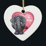 Ornamento De Cerâmica Dia de os namorados de elefante<br><div class="desc">Parada Animal Elephant Love and Hearts Day Gifts and Accessories (Presentes e Acessórios do Dia do Namorados Romântico de Elefante Romântico e Corações) apresenta nossa divertida trabalho de arte de um elefante bonito segurando um rosa bonito na boca com corações roxos, vermelhos e cor-de-rosa atrás dela criados pelo nosso talentoso...</div>