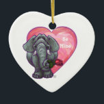 Ornamento De Cerâmica Dia de os namorados de elefante<br><div class="desc">Parada Animal Elephant Love and Hearts Day Gifts and Accessories (Presentes e Acessórios do Dia do Namorados Romântico de Elefante Romântico e Corações) apresenta nossa divertida trabalho de arte de um elefante bonito segurando um rosa bonito na boca com corações roxos, vermelhos e cor-de-rosa atrás dela criados pelo nosso talentoso...</div>